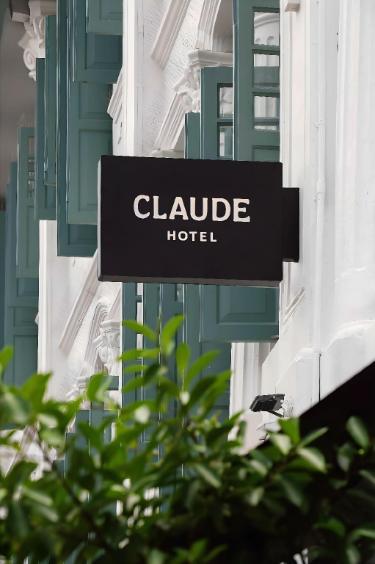 CLAUDE HOTELの看板と緑の窓枠