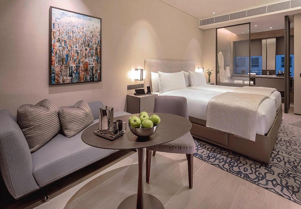 2台のベッドとソファ、机、テレビのあるStudio Twin