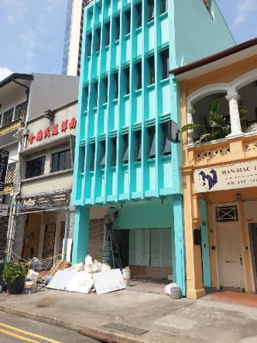 青緑の縦格子の建物と路面入口