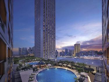 円形の屋外プールと周囲の高層ビル