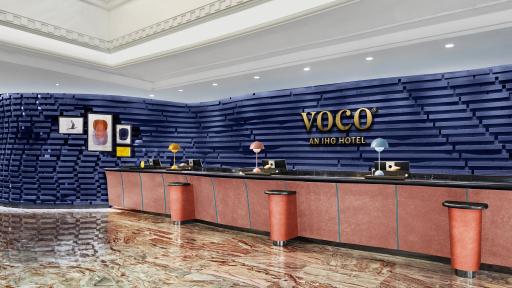 青い背景壁とvocoロゴのある横長の受付カウンター