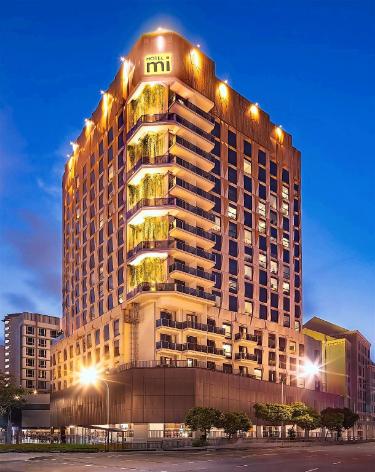 夜のHotel Miの看板と高層建物