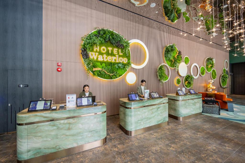 HOTEL Waterlooのロゴと受付カウンター、円形の植物装飾