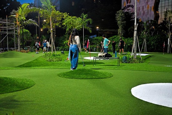 夜のUltraGolfでミニゴルフを楽しむ人々